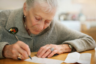 elderly person writing down new years resolution