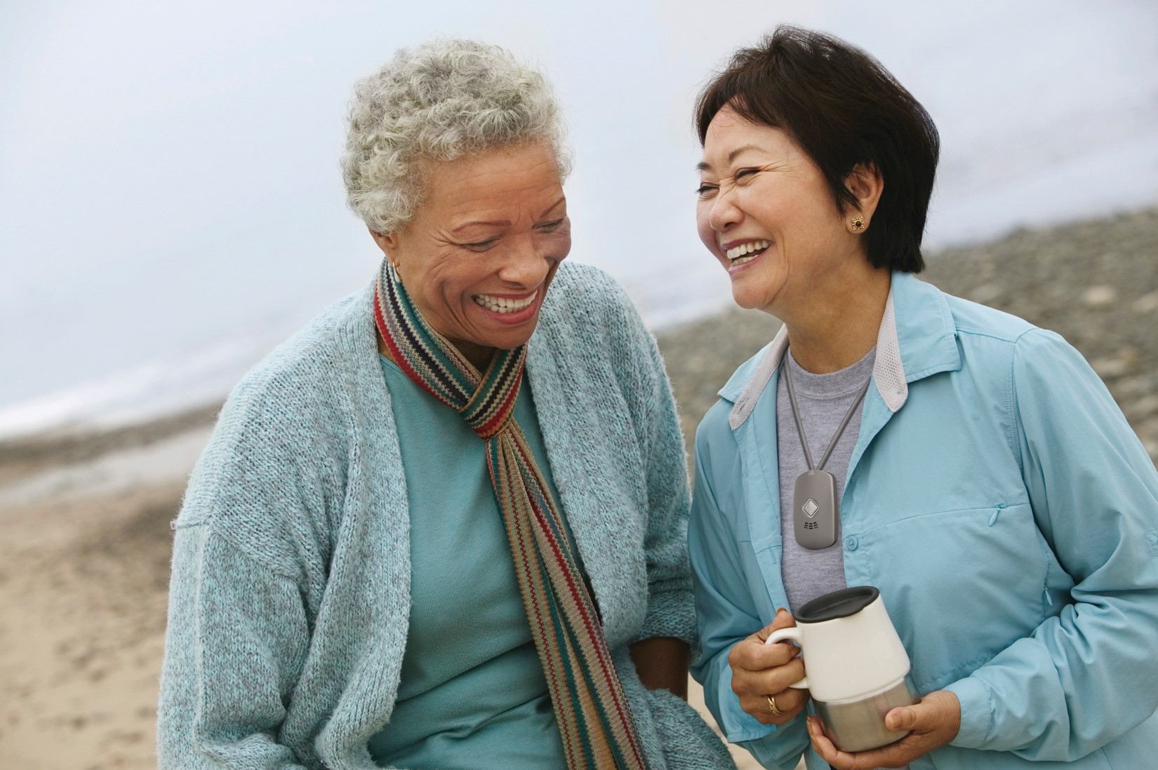 two elderly ladies on beach laughing