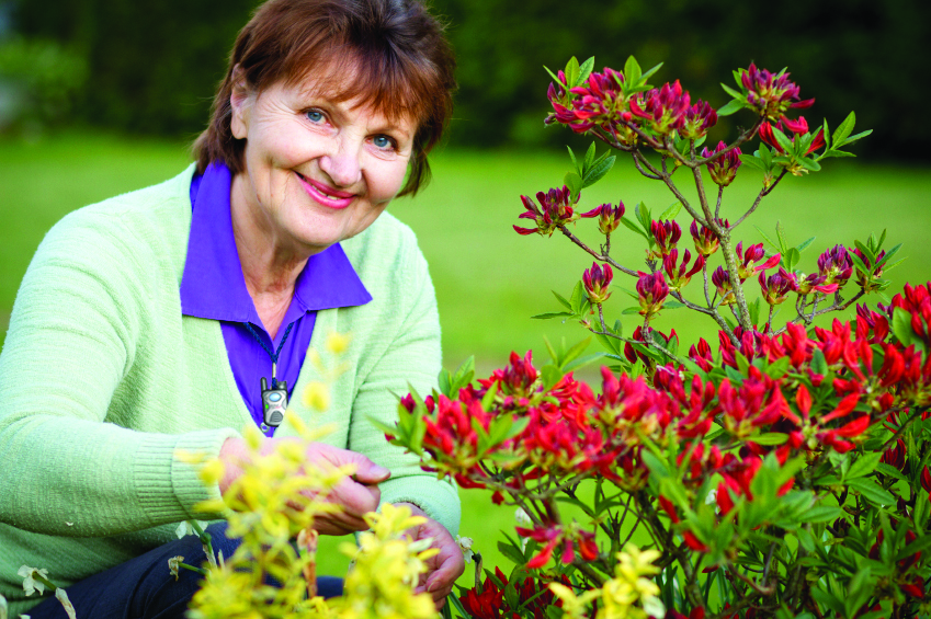 elderly woman with medical alert button in garden